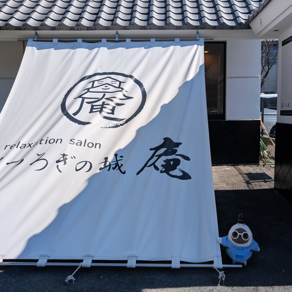 熊本市中央区「くつろぎの城 庵」はお城のような建物と大きなロゴ入りのれんが目印です。